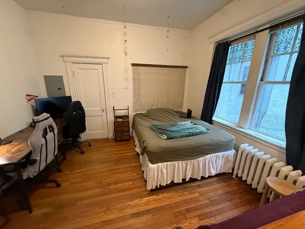 a bedroom with a bed and wooden floor