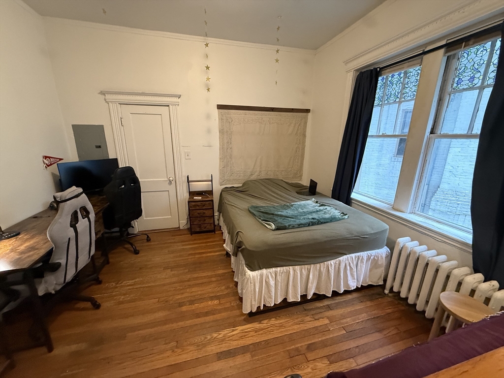 1111 Boylston Street, Unit 25 Boston, MA 02215 - Photo 2 of 9 a bedroom with a bed and wooden floor