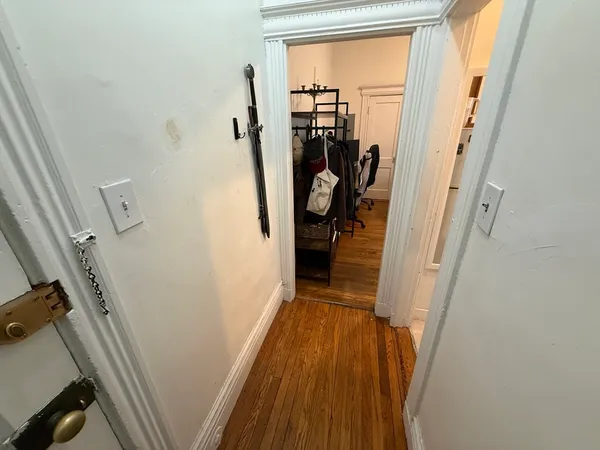 a view of a hallway with wooden floor and stairs