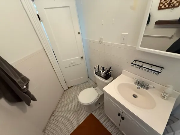a bathroom with a sink a toilet and a mirror