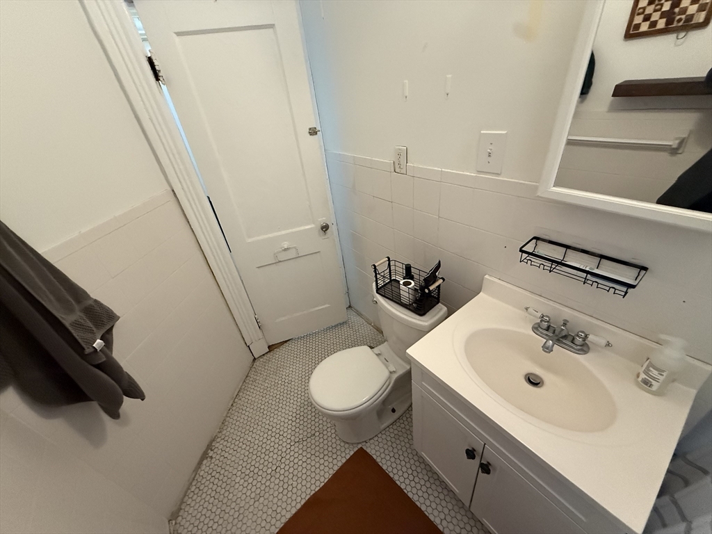 1111 Boylston Street, Unit 25 Boston, MA 02215 - Photo 7 of 9 a bathroom with a sink a toilet and a mirror