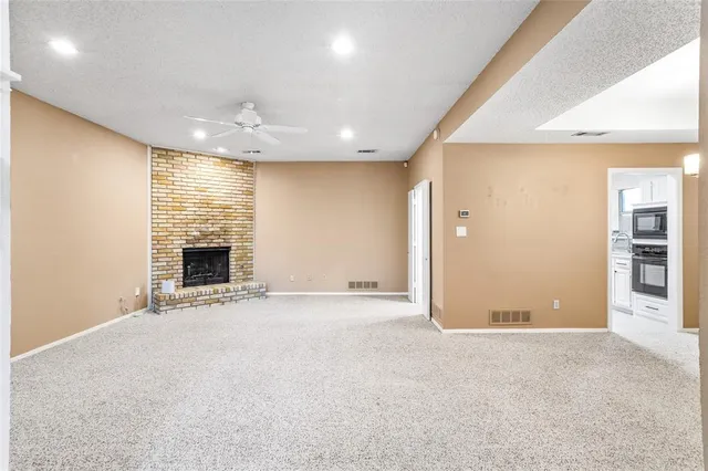 an empty room with fireplace and a window