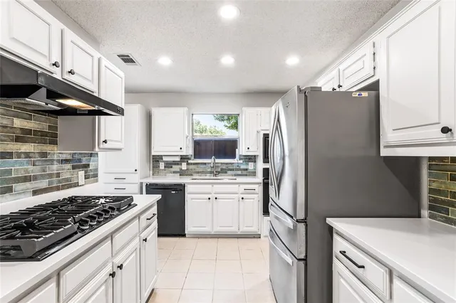 a kitchen with a stove a refrigerator and a sink