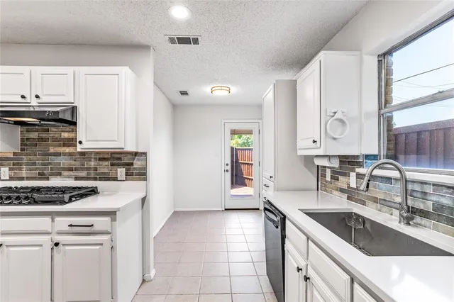 a kitchen with stainless steel appliances granite countertop a sink stove and cabinets