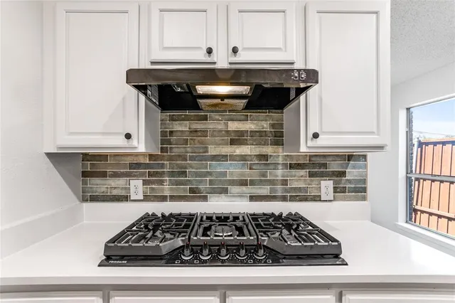 a kitchen with granite countertop a stove and cabinets