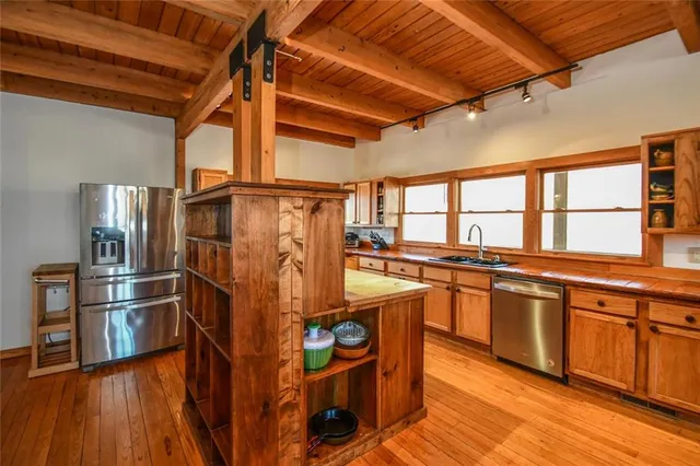 a bedroom with a bed a couch and large windows