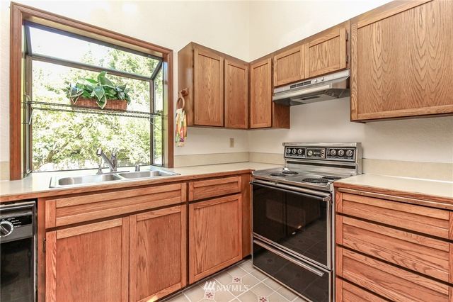 a kitchen with granite countertop white cabinets and a stove top oven