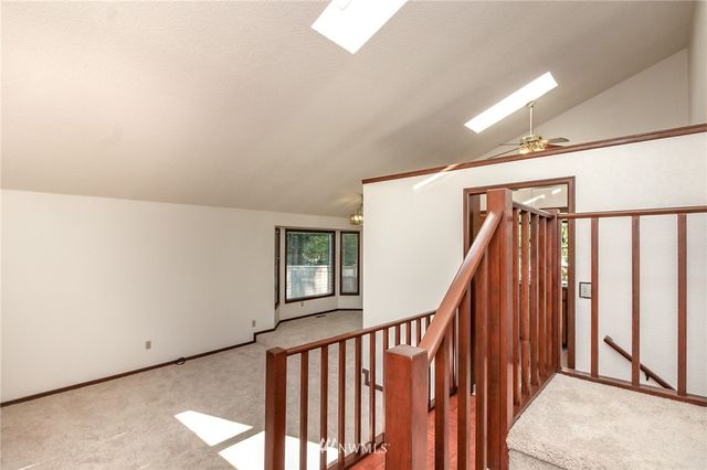 a view of staircase with railing and a window