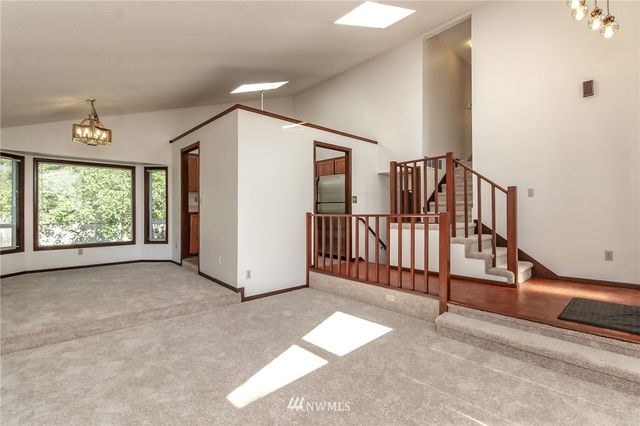 a view of a livingroom with a staircase and a ceiling fan
