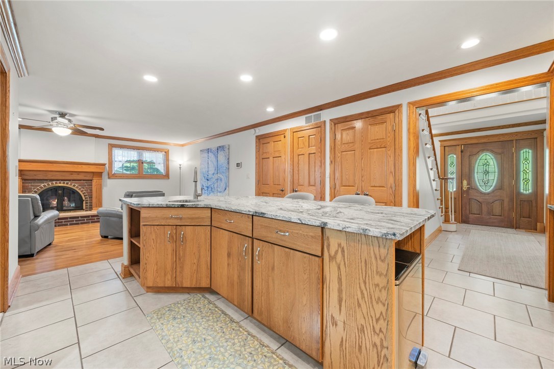 3871 Greentree Road Stow, OH 44224 - Photo 17 of 50 Kitchen island featuring a stone countertop, built-in sink, and wood cabinetry