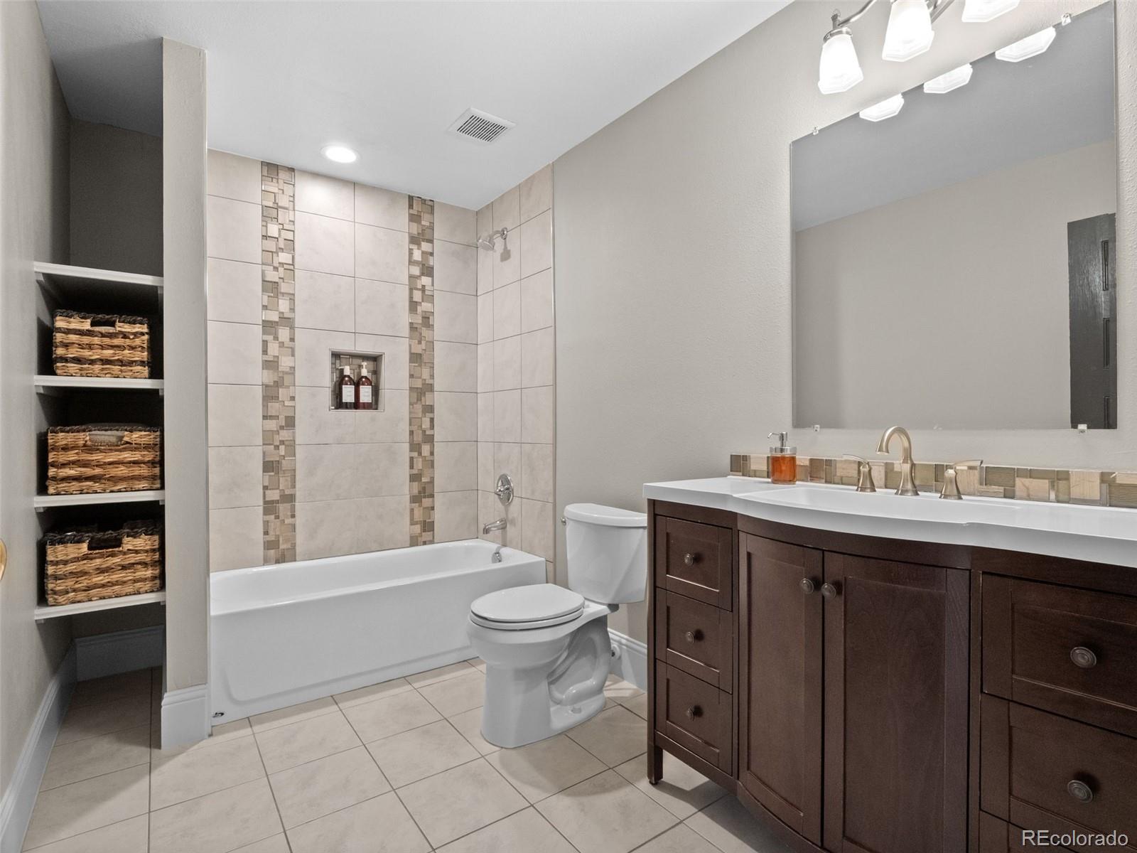 6595 West 46th Place Wheat Ridge, CO 80033 - Photo 23 of 48 a spacious bathroom with a double vanity sink a toilet and a bathtub