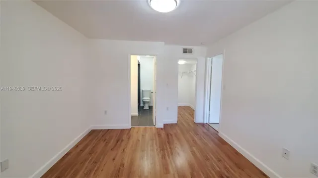 a view of a room with wooden floor and white walls