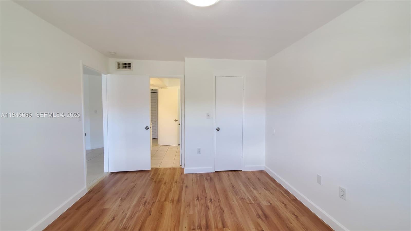 10500 Southwest 155th Court, Unit 1022 Miami, FL 33196 - Photo 21 of 41 a view of an empty room with wooden floor and a window