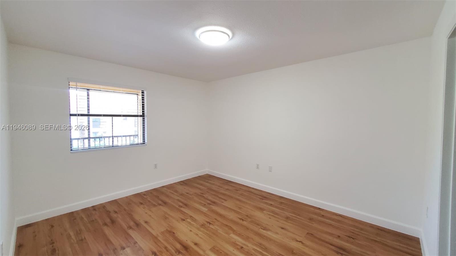 10500 Southwest 155th Court, Unit 1022 Miami, FL 33196 - Photo 23 of 41 an empty room with wooden floor and windows