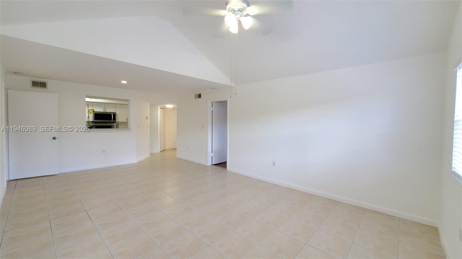 10500 Southwest 155th Court, Unit 1022 Miami, FL 33196 - Photo 3 of 41 an empty room with a large mirror and a ceiling fan