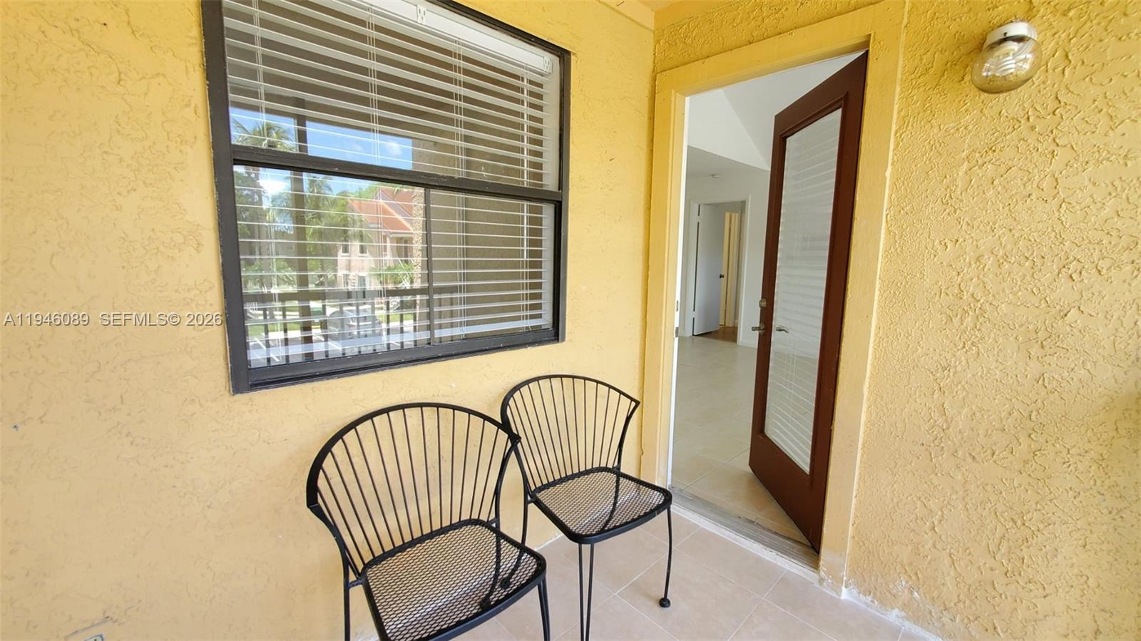 10500 Southwest 155th Court, Unit 1022 Miami, FL 33196 - Photo 34 of 41 a view of a door and chair in the balcony