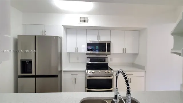 a kitchen with stainless steel appliances a refrigerator stove and microwave
