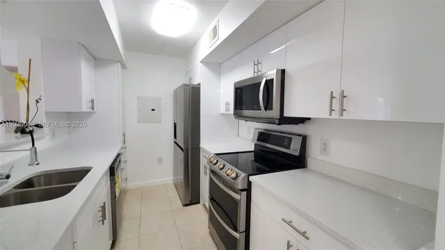 a kitchen with stainless steel appliances a stove a sink and a refrigerator