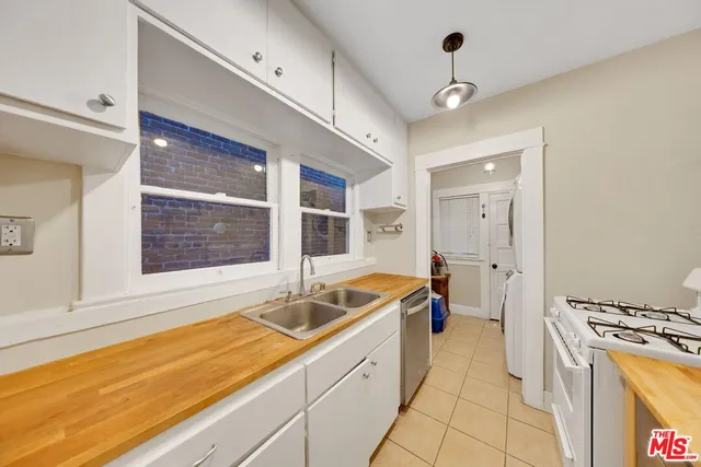 a large white kitchen with a stove a sink and a refrigerator