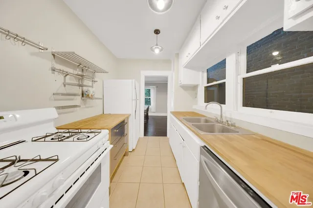 a kitchen with granite countertop a sink and a white cabinets
