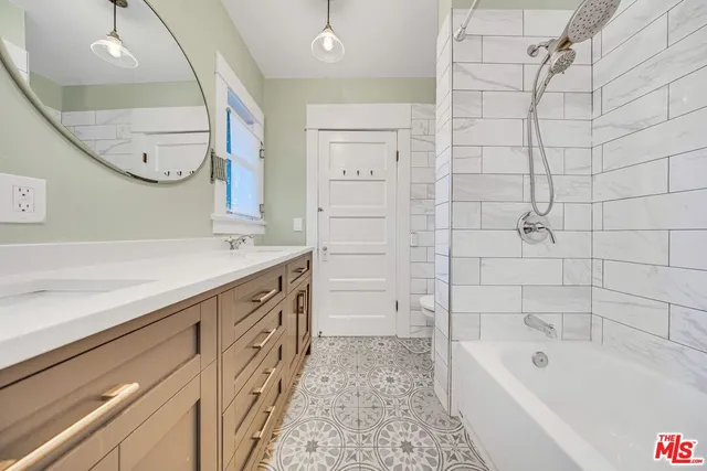 a bathroom with a sink a mirror a vanity and a bathtub