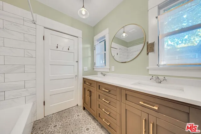 a view of an empty room with chandelier fan and wooden floor