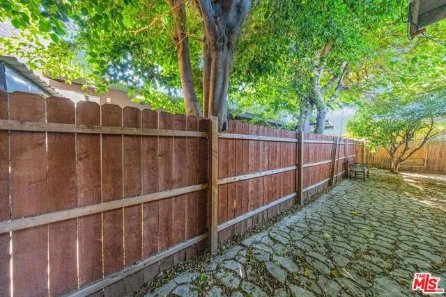 a view of a backyard with a bench and wooden fence