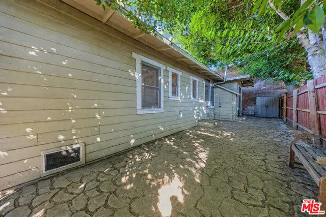 a view of backyard with wooden fence and large trees