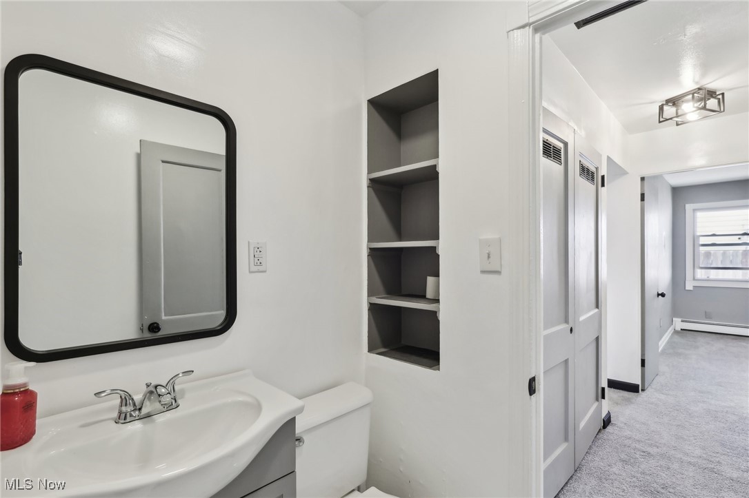 1829 Clyde Road Madison, OH 44057 - Photo 31 of 40 Bathroom featuring baseboard heating, vanity, and toilet