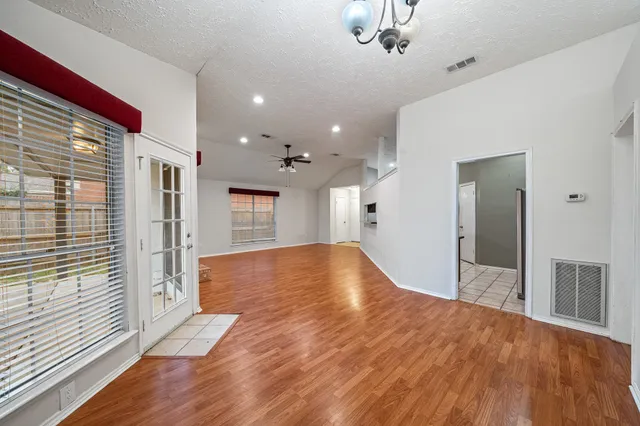 a view of empty room with wooden floor