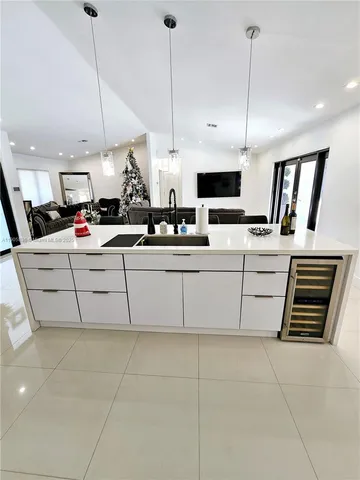 a kitchen with stainless steel appliances kitchen island granite countertop a sink counter top space cabinets and a wooden floor