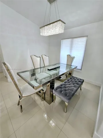 a living room with a table and a chandelier