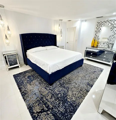 a large bedroom with a bed and a flat screen tv