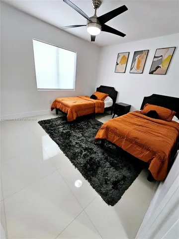 a bedroom with two bed and a painting on the wall