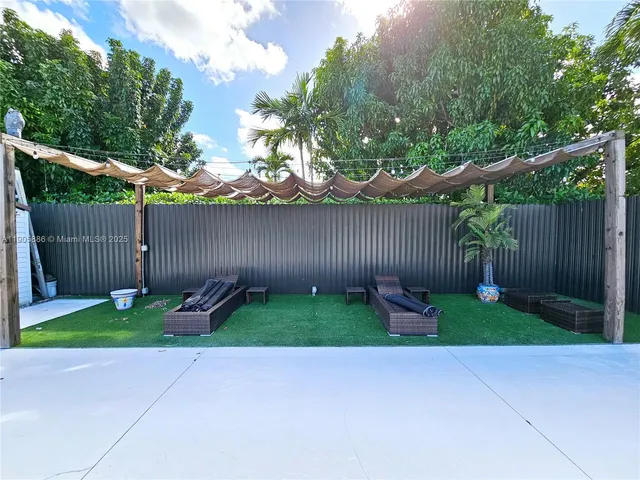 a view of a house with a patio and a yard