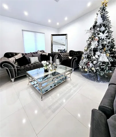 a living room with furniture potted plant and a chandelier
