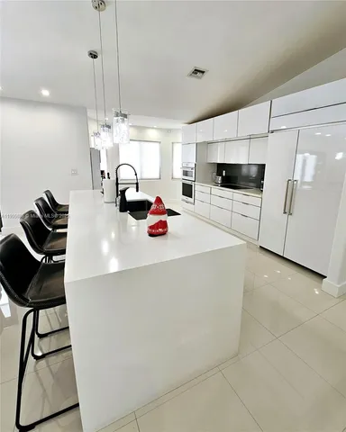 a kitchen with stainless steel appliances a stove a sink a microwave and cabinets