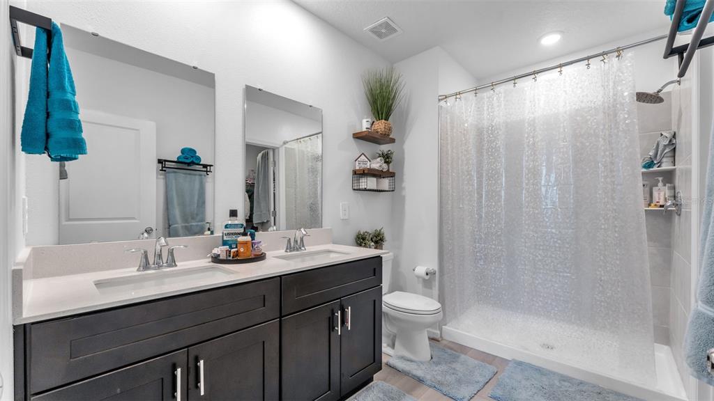 1624 Marksman Road Eagle Lake, FL 33839 - Photo 19 of 42 a bathroom with a double vanity sink toilet and shower