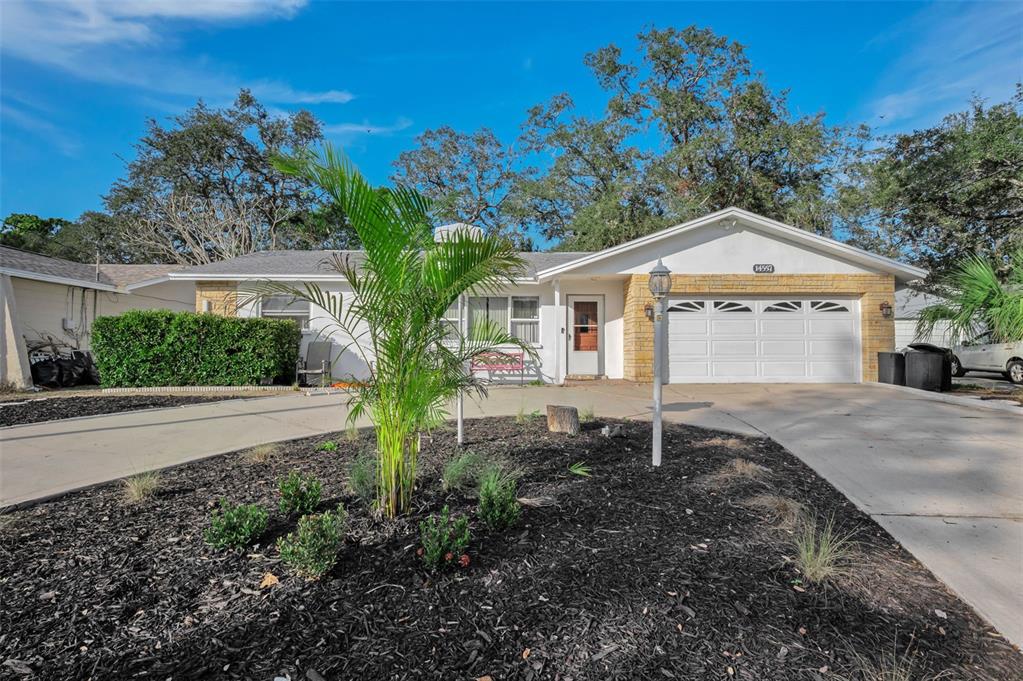 14557 Apache Avenue Largo, FL 33774 - Photo 1 of 50 a front view of a house with a yard and garage