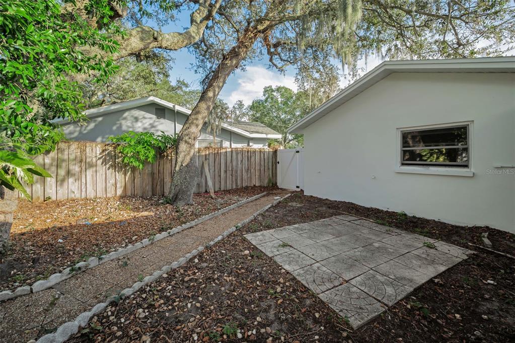 14557 Apache Avenue Largo, FL 33774 - Photo 12 of 51 a backyard of a house with large trees and wooden fence