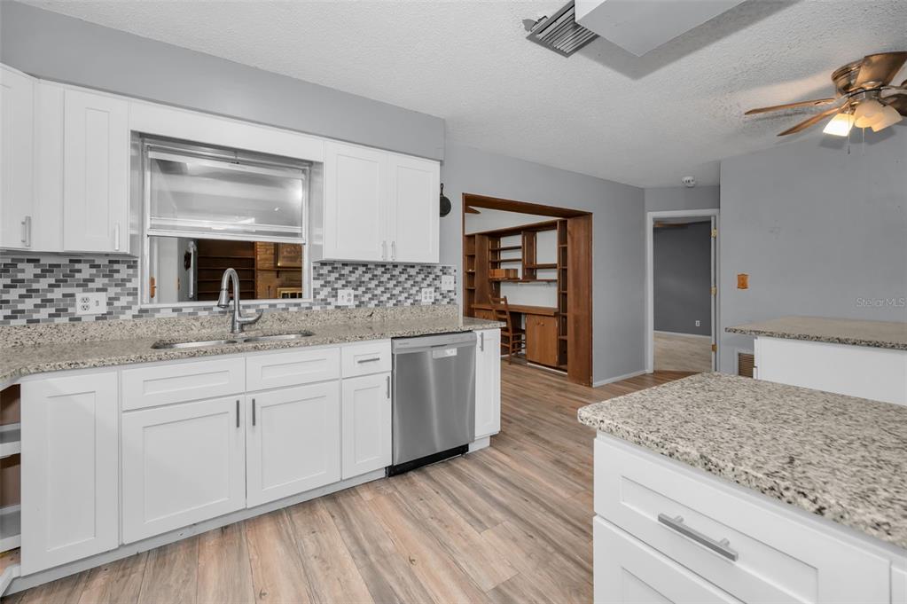 14557 Apache Avenue Largo, FL 33774 - Photo 13 of 50 a spacious bathroom with a granite countertop sink and a mirror