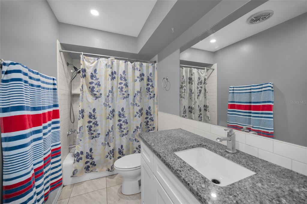 14557 Apache Avenue Largo, FL 33774 - Photo 18 of 51 a bathroom with a granite countertop toilet sink and shower