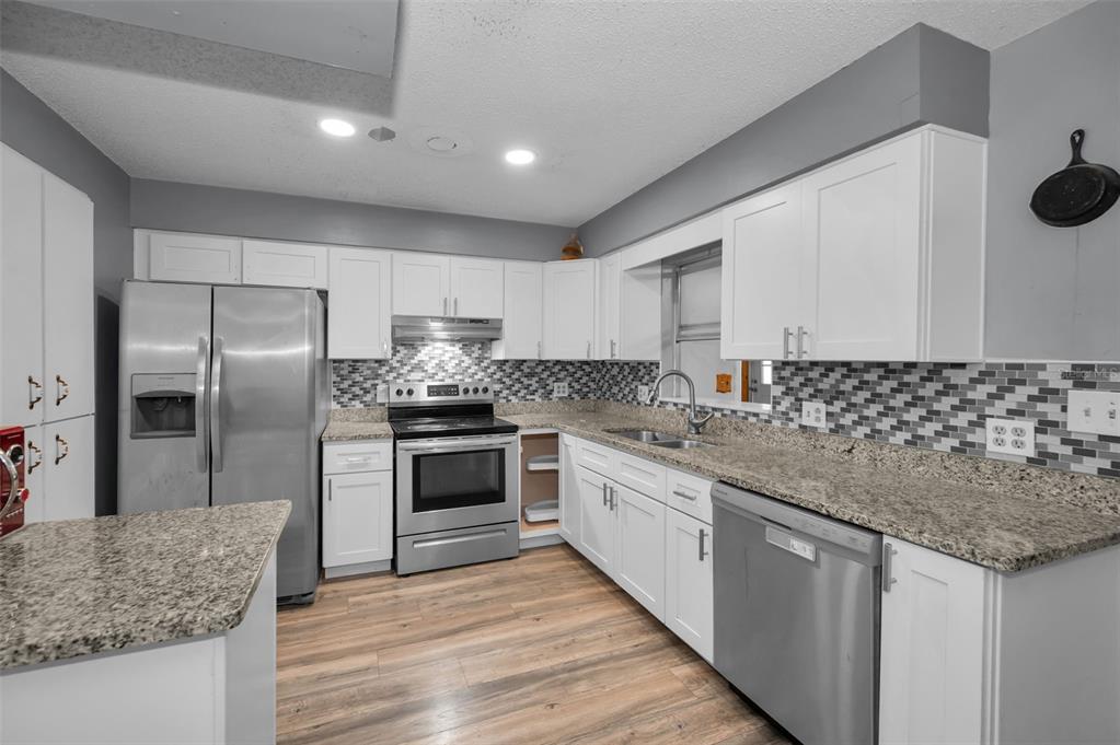 14557 Apache Avenue Largo, FL 33774 - Photo 8 of 50 a kitchen with stainless steel appliances granite countertop a sink stove and refrigerator