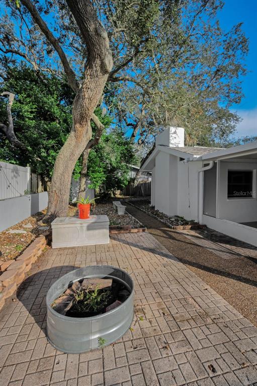 14557 Apache Avenue Largo, FL 33774 - Photo 10 of 51 a backyard of a house with barbeque oven and a table and chairs