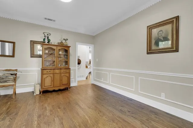 a view of a bedroom with wooden floor cabinet and window