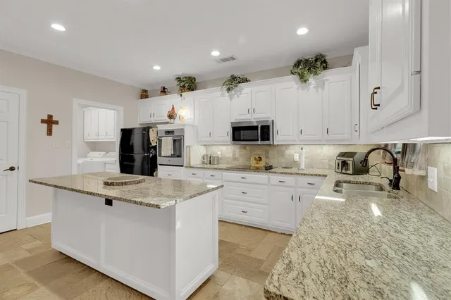 a kitchen with granite countertop a sink a stove and cabinets