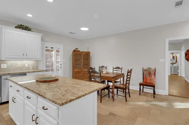 a kitchen with granite countertop kitchen island cabinets and wooden floor