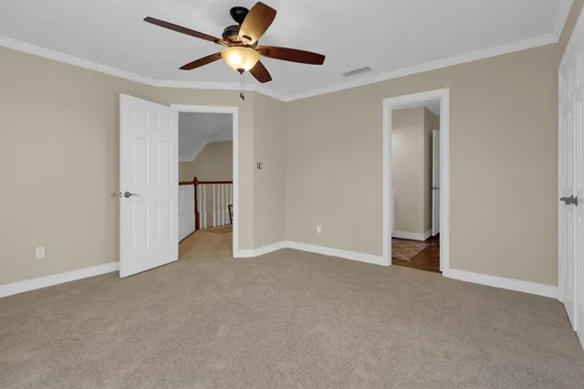 an empty room with closet and a ceiling fan