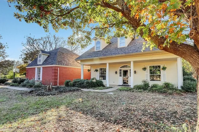 a front view of house with yard and trees around