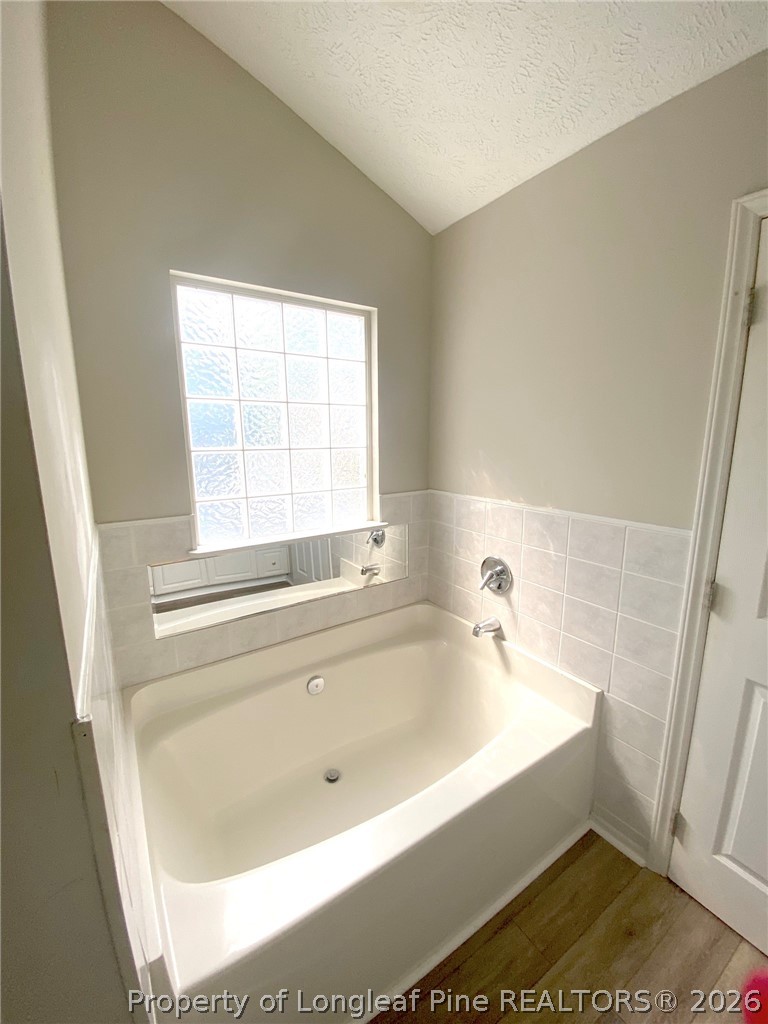 5715 Walkabout Road Hope Mills, NC 28348 - Photo 9 of 16 a bathroom with a bathtub and window